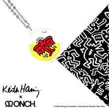 Load image into Gallery viewer, Keith Haring art with red flying devil printed on round clear acrylic pendant filled with yellow liquid 
