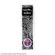 Load image into Gallery viewer, Keith Haring art with eight dancing rainbow men printed on round clear acrylic pendant filled with purple liquid