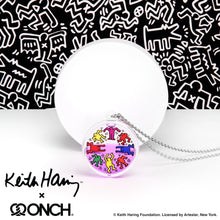 Load image into Gallery viewer, Keith Haring art with eight dancing rainbow men printed on round clear acrylic pendant filled with purple liquid. Black and white Keith Haring all over print background with collaboration logo with designer ONCH
