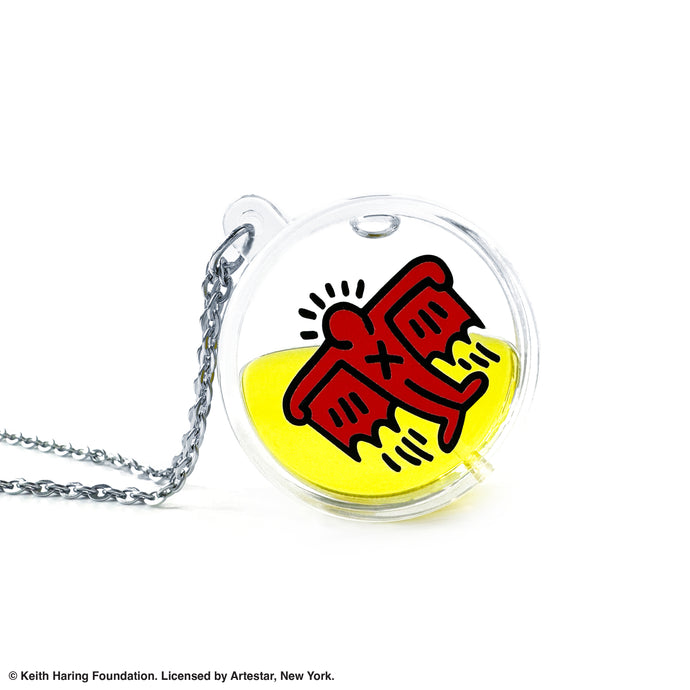 Keith Haring art with red flying devil printed on round clear acrylic pendant filled with yellow liquid 