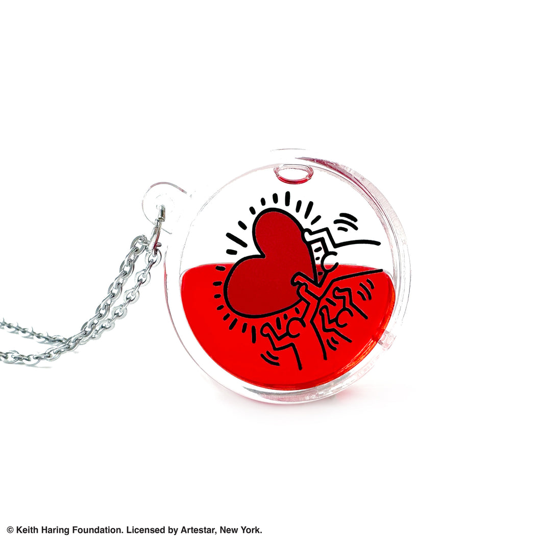 Keith Haring art with three men holding up red heart printed on round clear acrylic pendant filled with red liquid